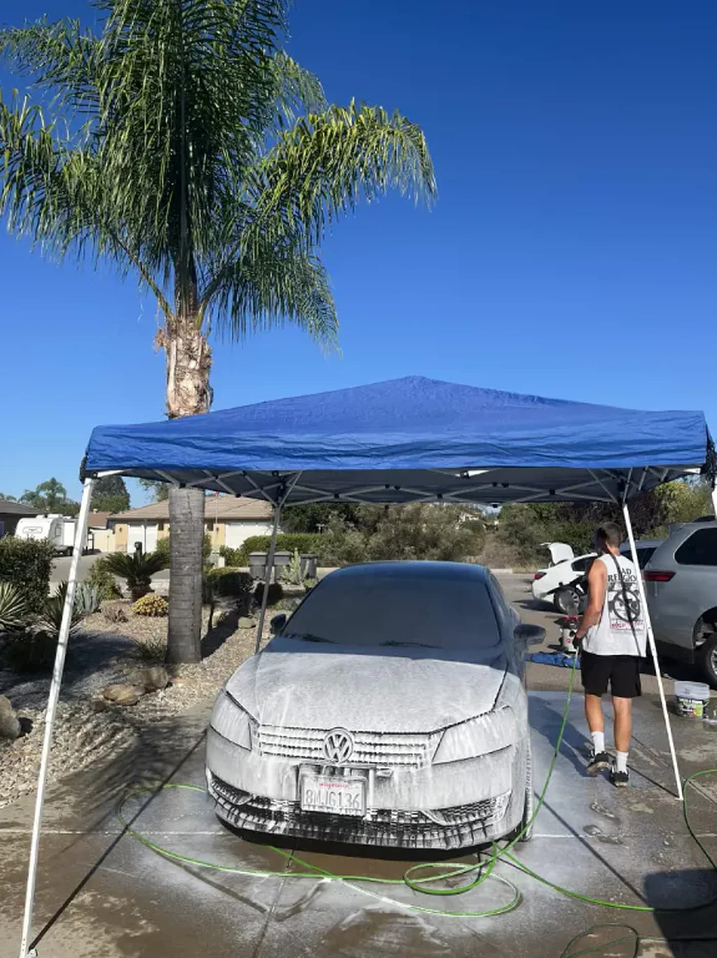 A&N detailer washing a vehicle in a Ramona driveway