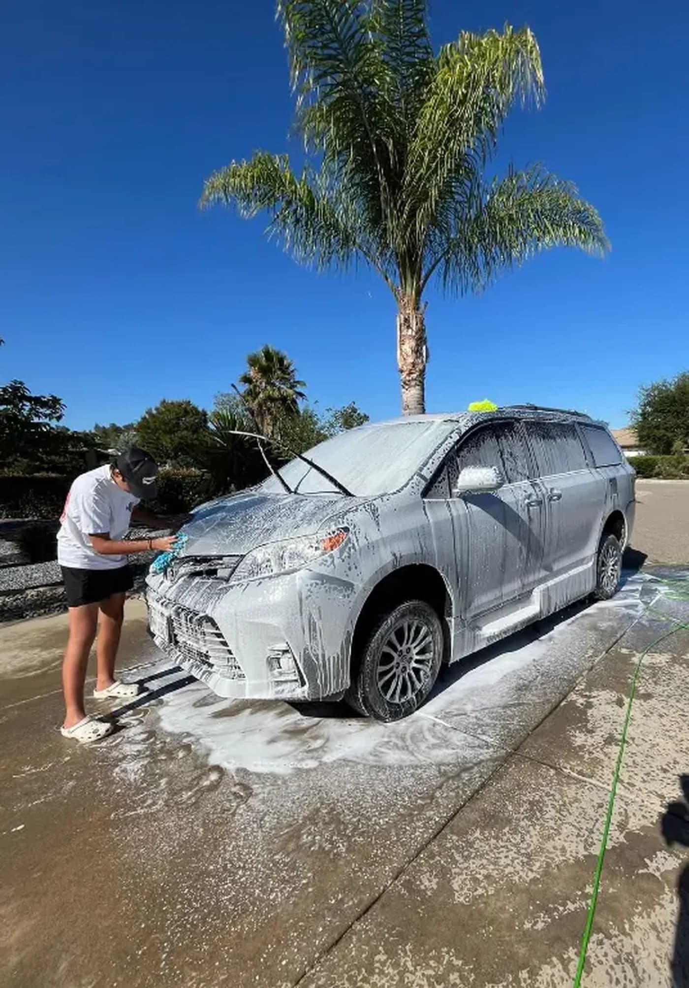 A&N detailer hand washing a vehicle in a Ramona driveway