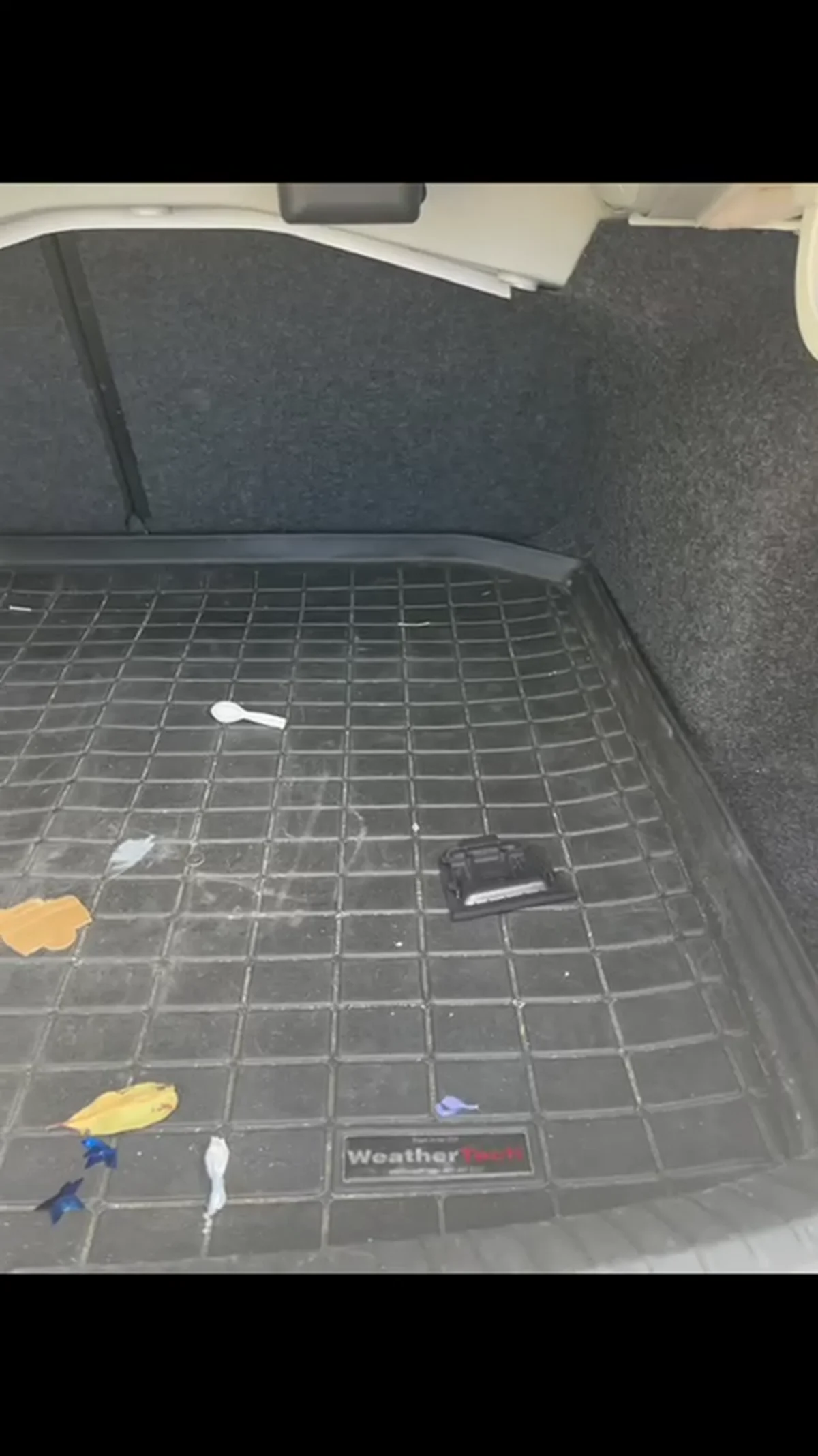 Volkswagen trunk liner before detailing with loose debris